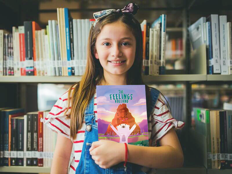Happy-Little-Girl-Holding-a-Book-Mockup-at-the-Library
